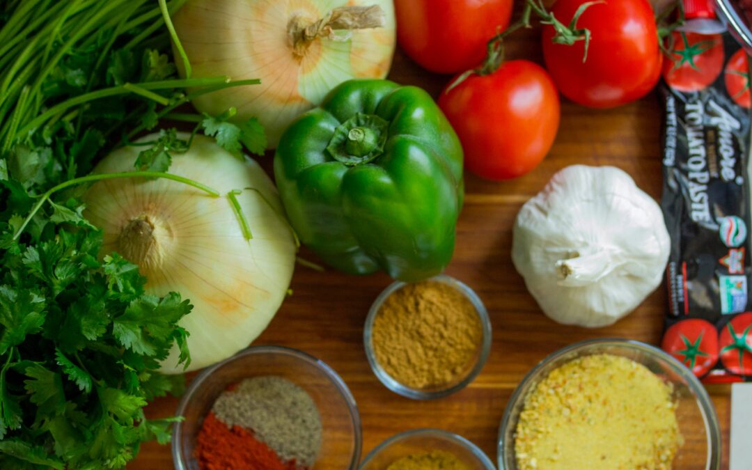 peppers, tomatoes, onions, and spices on a table