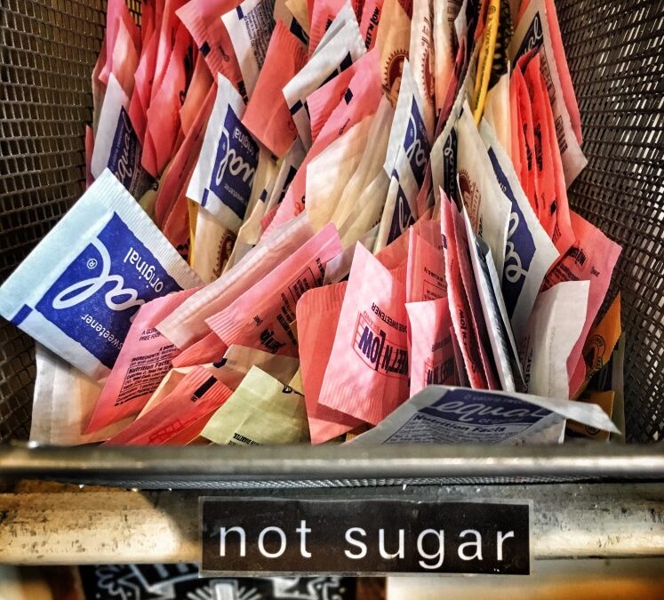 Packets of sugar substitutes in a basket